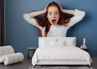 Young redhead woman showing shock and amazement Wall mural