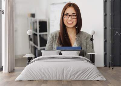 Young smiling woman holding files in office Wall mural