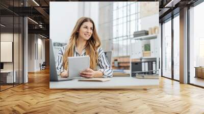 Young smiling woman holding notepad in office Wall mural