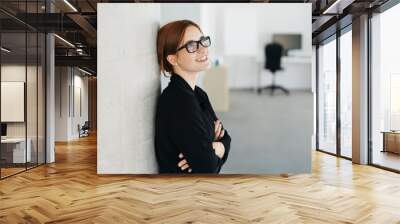 Young visionary businesswoman standing thinking Wall mural