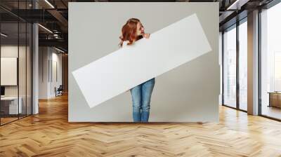 Young woman holding a blank panorama banner Wall mural