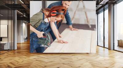 Young woman preparing to use a power tool Wall mural