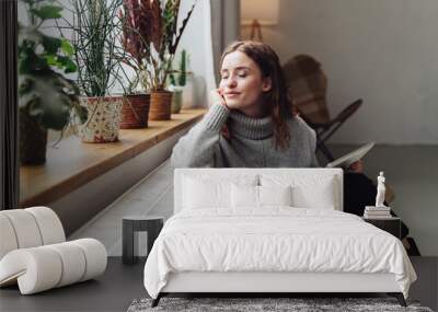 young woman relaxed at heater with tablet in hand Wall mural