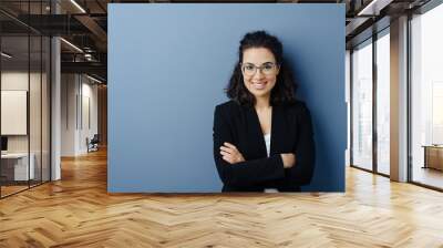 Young woman with folded arms and cheerful smile Wall mural