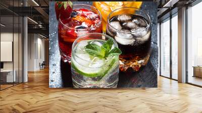 assortment of iced fruit drinks on a dark background, vertical Wall mural