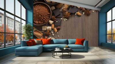 chocolate, cocoa, nuts and spices on wooden background, top view Wall mural