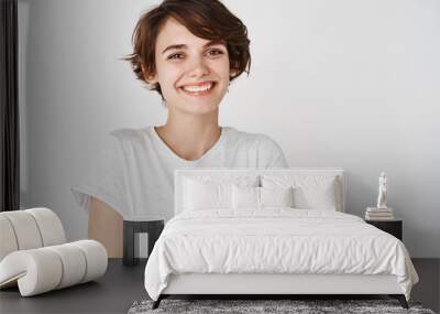 Close-up of happy professional girl cross arms on chest, smiling at camera, white background Wall mural