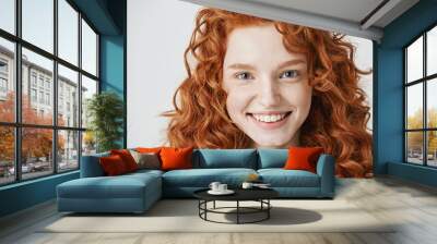 Close up of redhead beautiful girl with freckles smiling looking at camera over white background. Wall mural