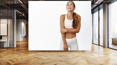 Happy sportswoman 30 years old, wearing sportsbra and leggings, laughing and smiling, enjoying active and healthy sport lifestyle, white background Wall mural