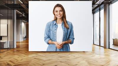 How may I help you. Smiling young woman with fair hair holding hands together and looking friendly at camera, happy emotions, white background Wall mural