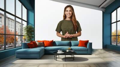 Image of happy and confident brunette woman, holding hands together, self-assured assertive pose, assisting, helping out with advice, ready to listen, standing against white background Wall mural