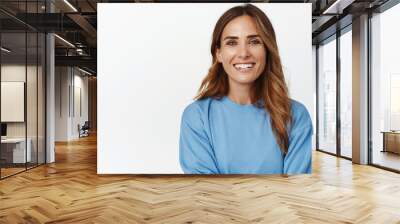 Portrait of ambitious and confident adult 30s woman, cross arms and smiling happy at camera, looking forward, standing against white background Wall mural