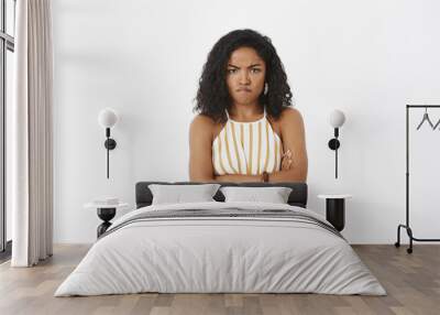 portrait of angry and mad cute african american woman with curly hairstyle crossing arms on chest in Wall mural