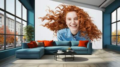 Portrait of beautiful cheerful redhead girl with flying curly hair smiling laughing looking at camera over white background. Wall mural