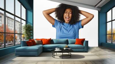 Portrait of distressed african american woman screaming and pulling hair out of head, shouting depressed and upset, feeling sad, standing over white background Wall mural