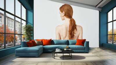 Portrait of redhead girl posing back turning face to camera. Wall mural