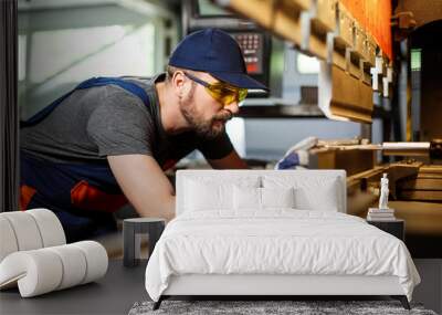 portrait of worker near metalworking machine, steel factory background. Wall mural