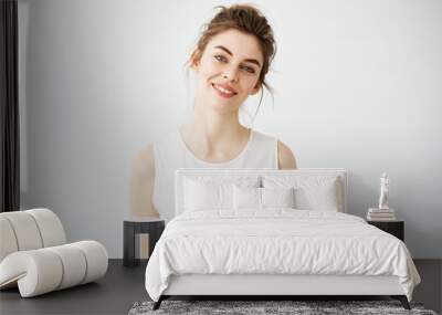 Portrait of young beautiful brunette girl smiling looking at camera over white background. Wall mural