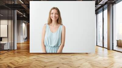 Portrait of young beautiful pretty girl smiling looking at camera over white background. Wall mural