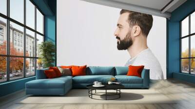 Profile portrait of handsome bearded adult european man with trendy haircut, standing over gray background. Hairdresser makes photo of new haircut he did for visitor to post it on site Wall mural