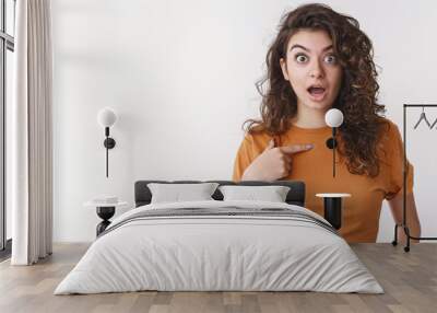 Shocked girl being surprised she picked chosen unwilling participate pointing herself widen eyes disturbed worried open mouth displeased, arguing not want involved, standing white background Wall mural