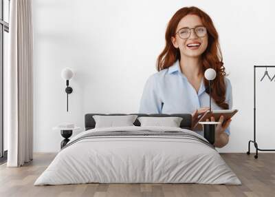 Smiling business girl, office worker in glasses, using digital tablet for work, laughing and looking happy, standing against white background Wall mural