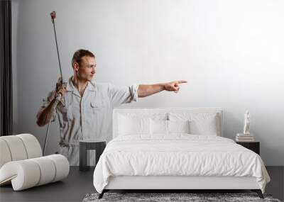 Worker holding spray gun over white wall. Copy space. Wall mural