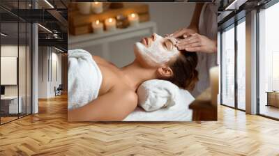 Young beautiful girl in mask for face relaxing in spa salon. Wall mural