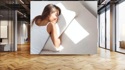 Young beautiful girl lying on bed early in morning. Shot from above. Wall mural