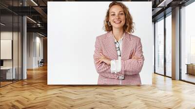 Young professional business woman cross arms on chest, smiling and looking like real professional, white background Wall mural