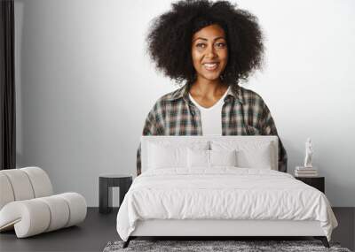 Young smiling Black woman looking friendly, holding hands together and communicating with client, offer assistance or help, standing over white background in ready pose Wall mural