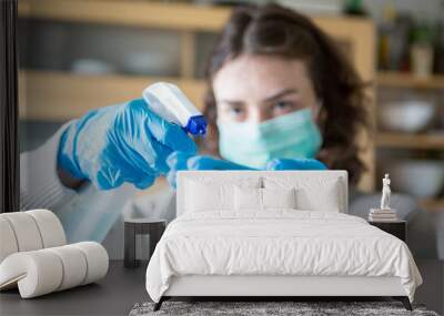 Coronavirus Epidemic Outbreak. Woman in protective face mask using disinfectant. Wall mural