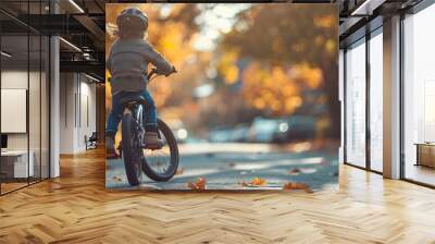 A child riding their bicycle down a quiet street, the wind in their hair and a smile on their face. Wall mural