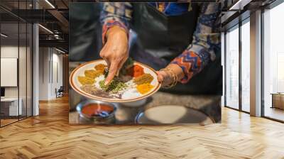 Woman in kitchen pointing out South Asian spices Wall mural