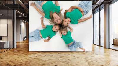 Top view of a portrait of a happy group of little girls and her mother, dressed in a green t-shirts. Wall mural