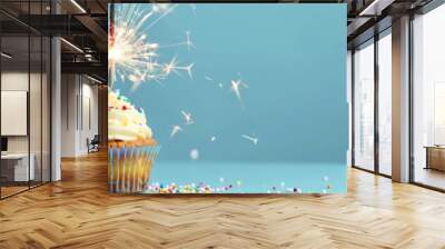 Happy birthday party celebration congratulation greeting card banner long - Cup cake with sparkling sparkler, isolated on bright blue table background Wall mural