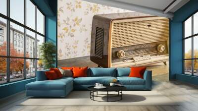 Old retro vintage radio on a aged wooden table illuminated by the sun Wall mural