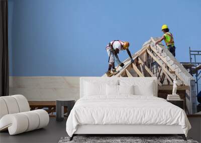 Carpenters are working on the house roof at construction Wall mural