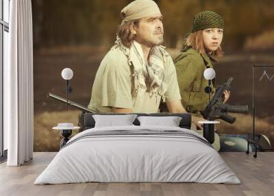 Guerilla, partisan or territory army couple watching around armed with guns Wall mural