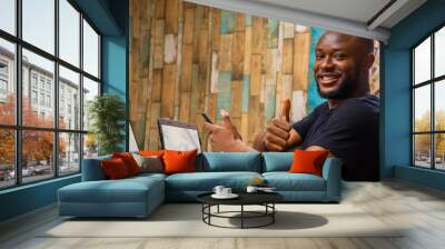 young black man working on his laptop in his office Wall mural