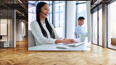 If it needs fixing, Ill find a way. Shot of a young woman using a headset and computer in a modern office. Wall mural