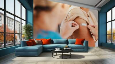 Healthcare, patient and plaster on arm for covid vaccine, flu shot or arthritis or osteoarthritis injection in hospital for health and wellness. Woman and nurse or doctor together during consultation Wall mural