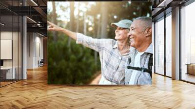 Hiking, adventure and freedom with a senior couple enjoying and exploring the forest or woods and bonding together. Happy, carefree and exploring retired man and woman looking at the views outdoors Wall mural