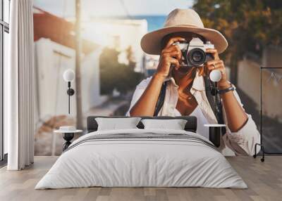 Photographer, travel or tourist taking pictures or photos outdoors in a new town. Traveler using a camera while on a trip at a vacation or holiday location on a sunny day doing a photoshoot Wall mural