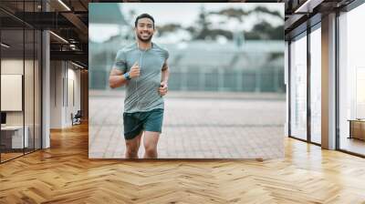 Sports, portrait and male athlete running with earphones for music, radio or podcast for motivation. Fitness, exercise and man runner in outdoor cardio workout routine for race or marathon training. Wall mural