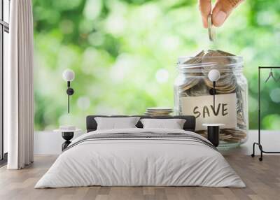 Hand putting Coins in glass jar for money saving financial  Wall mural