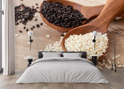 organic Black and white sesame seeds in a wooden spoon , top view or overhead shot Wall mural