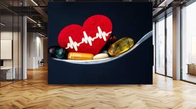 the colorful medical supplement and drug pills with red heart in spoon , pharmaceutical cardiology drugs for heart health care disease concept Wall mural