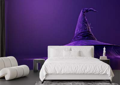 Witch hat with cobwebs on purple background with copy space Wall mural