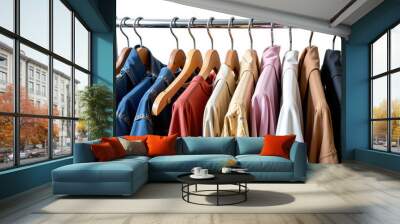 Clothes rack displaying colorful clothing items on wooden hangers Wall mural